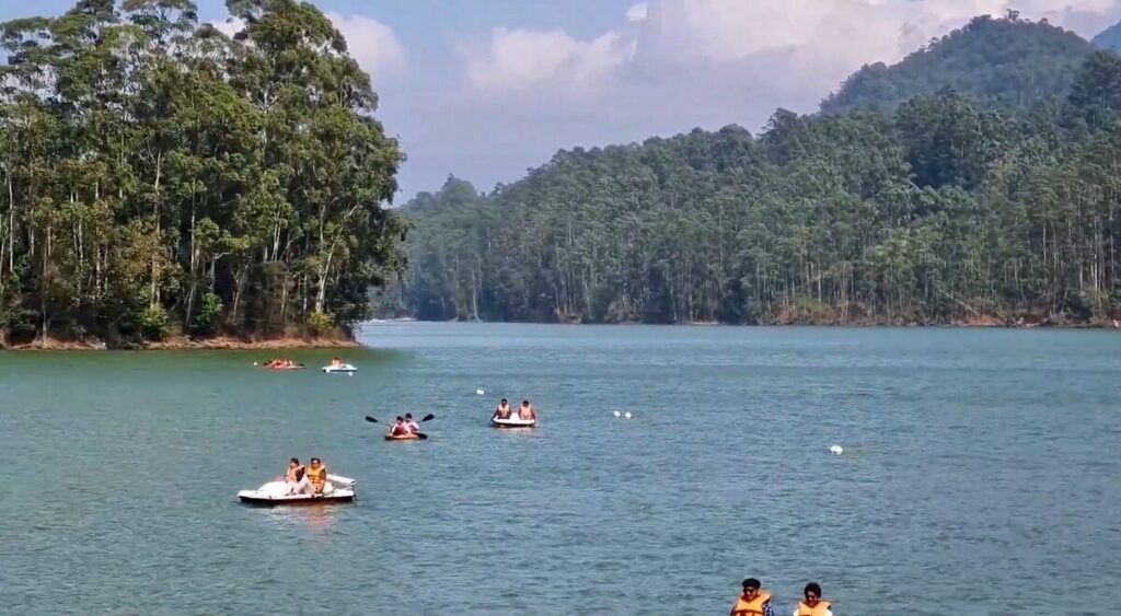 Boating at Mattupetty Dam with calm water and green hills all around