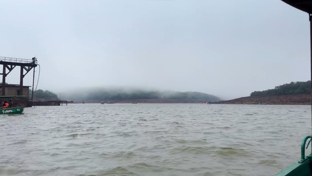 Boating at Veena Lake surrounded by green hills in Mahabaleshwar