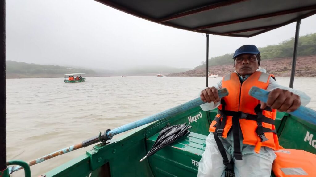 Boating at Veena Lake surrounded by green hills in Mahabaleshwar